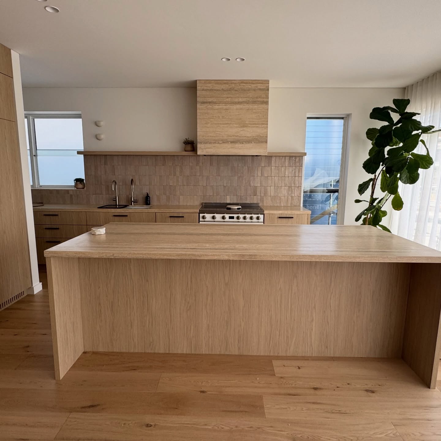 Travertine kitchen island and rear bench with oak joinery, protected end to end with Stone Shield film