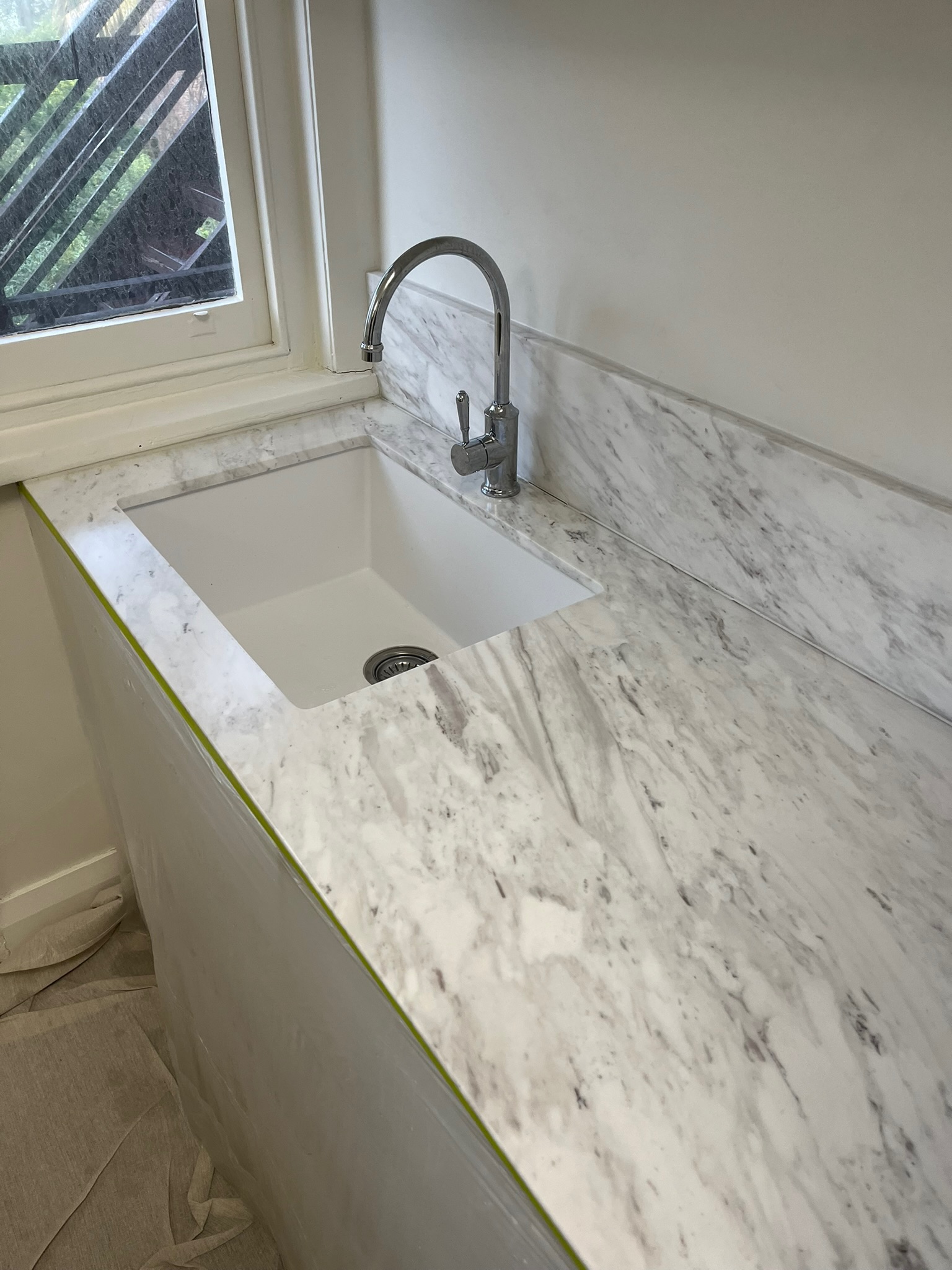 Stone specialist working beside a veined kitchen island